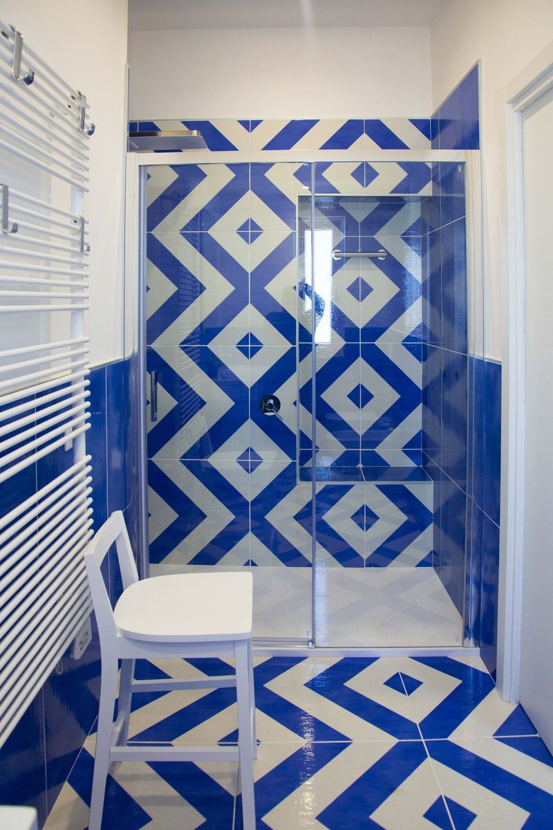 Bagno con doccia walk-in e maiolica blu e bianca a rombi